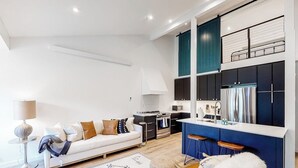 A modern living room with a sofa, a coffee table, and a dining area with chairs. - Gorgeous, modern mountain view condo with deck & great kitchen (Wilson)