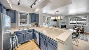 Una cocina moderna con una isla grande, electrodomésticos integrados y mucha luz natural.