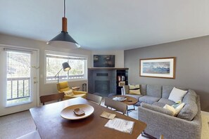 Ein modernes Wohnzimmer mit Esstisch, Sofa und Kamin.