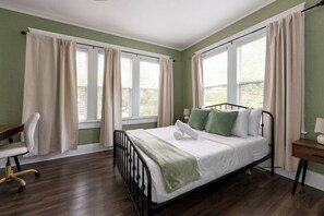 Un dormitorio con una cama, un escritorio y una silla.