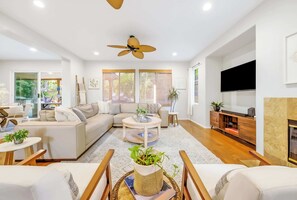 A modern living room with a sofa, coffee table, and TV. - **NEW**Backyard Dream - 5BR l Pool l Spa (Vista)