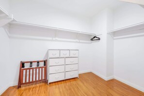A room with a white dresser, a wooden crib, and a white shelving unit against a white wall. - **NEW**Backyard Dream - 5BR l Pool l Spa (Vista)