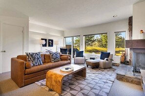 Ein modernes Wohnzimmer mit einem braunen Ledersofa, einem Couchtisch aus Holz und einem Kamin.