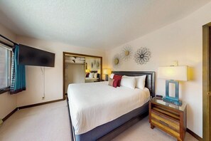 Una habitación de hotel con cama, mesita de noche, lámpara y decoración mural.