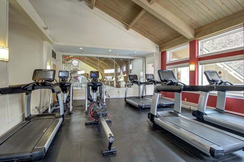 A gym with treadmills, elliptical machines, and stationary bikes.