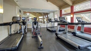 Una palestra con tapis roulant, ellittiche e cyclette.