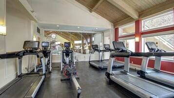 A gym with treadmills, elliptical machines, and stationary bikes.
