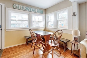 A room with a wooden table and chairs, a bench, a lamp, and a sign that reads 'BEACH'. - Comfortable home steps from beach with deck, grill, & washer/dryer (Hampton)