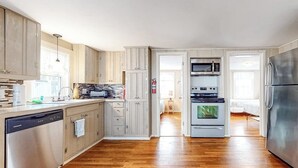 Una cocina moderna con armarios de madera, electrodomésticos de acero inoxidable y lavavajillas.
