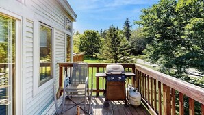 Eine Terrasse mit Grill, einem Stuhl und einer Gasflasche.