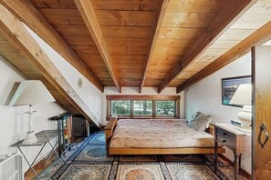 A bedroom with a wooden ceiling, a bed, a window, and a radiator. - Dog-friendly & charming mountain chalet w/ fireplace (Franconia)