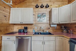 A wooden cabin interior with a kitchen area featuring a sink, stove, and cabinets. - Summer Fun, Lake View, Firepit, Outdoor grilling, walk to the lake (Naples)