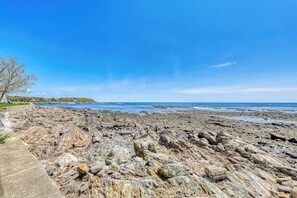 A rocky shoreline with a clear sky and a distant view of the ocean. - Charming oceanfront house with incredible beach views, BBQ area & firepit (York)