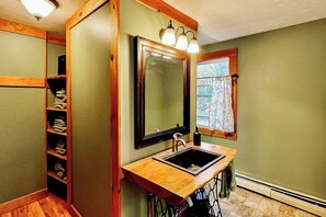A bathroom with a wooden vanity, a sink, a mirror, and a towel rack. - Immaculate All-Season Retreat with Must-See Game Room! (Bethel)