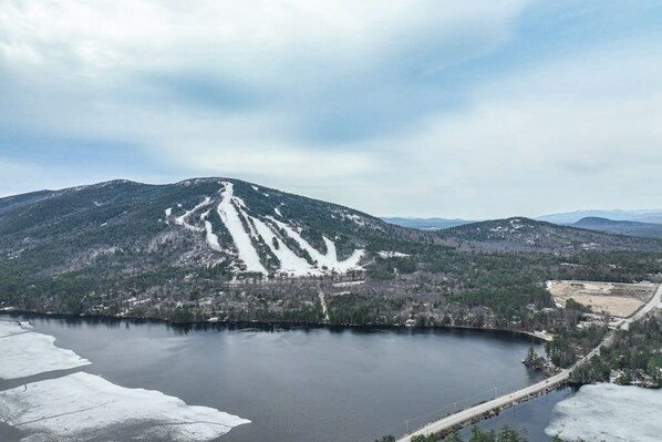A mountainous landscape with a lake, roads, and sparse buildings.