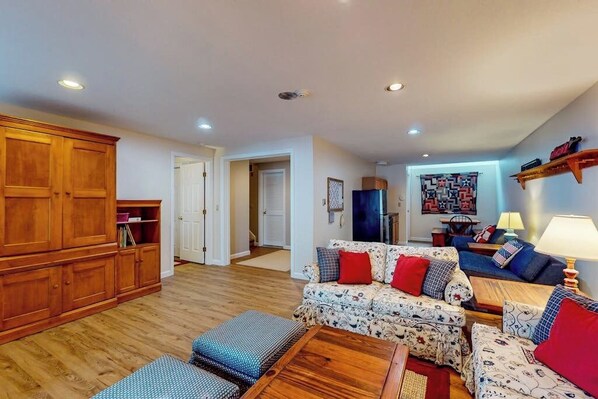 A living room with a sofa set, wooden cabinet, and a lamp.