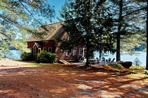 A lodge with a wooden exterior, a dock, and a view of a lake.