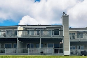 Un immeuble à plusieurs étages, doté de balcons, d’une cheminée centrale et d’un toit plat.
