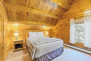 A wooden cabin bedroom with a bed, nightstands, and a window. - Charming Log Cabin w/ Free WiFi plus a Community Pool, Tennis, & Clubhouse (Bridgton)