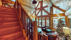 Ein Holzinnenraum mit Treppe, Kamin und Weihnachtsbaum.