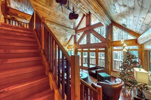 Ein Holzinnenraum mit Treppe, Kamin und Weihnachtsbaum.
