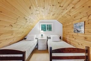 A room with wooden walls and a sloped ceiling, two beds, a window, a nightstand, and a painting. - Rustic lakefront cabin w/gas grill, firepit, kayaks, one canoe, A/C - 2 dogs OK (Leeds)