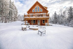 A log cabin with a balcony, surrounded by snow-covered trees. - The Escape at ThunderSnow Sunday River lodge with Stunning Views to Wake Up to (Bethel)