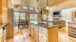 Una cocina amplia con armarios de madera, una isla central y un comedor con mesa y sillas.