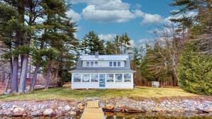A house with a dock leading to a pond, surrounded by trees. - Lakefront home with private dock, kayaks, firepit, grill, & sunroom (Monmouth)
