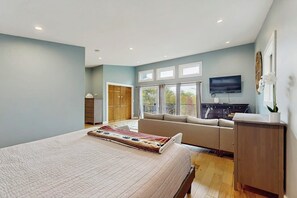 Ein Schlafzimmer mit einem Bett, einem Sofa, einem Fernseher und einem Schreibtisch.