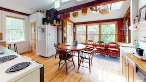 A kitchen with wooden floors, a round table, and chairs, a stove, and a ceiling fan. - Historic home with porch & mountain/valley views - great for weddings (Paris)