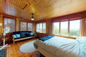 A wooden cabin room with a bed, a sofa, and large windows. - Historic home with porch & mountain/valley views - great for weddings (Paris)