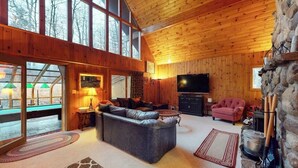 Ein gemütliches Wohnzimmer mit Kamin, Fernseher und einer Steinwand.