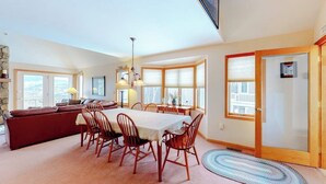 A dining area with a table, chairs, and a sofa. - Cute townhome on the slopes with trail access, deck, hot tub & pool (Newry)