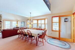 A dining area with a table, chairs, and a sofa. - Cute townhome on the slopes with trail access, deck, hot tub & pool (Newry)