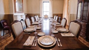 A formal dining room with a long table set for a meal, elegant chairs, a chandelier, and a large mirror. - The Hillard - A Private Historic Estate 1865 (Wilkes-Barre)