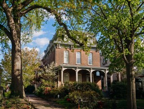 A two-story brick house with a porch, surrounded by trees and a garden. - The Hillard - A Private Historic Estate 1865 (Wilkes-Barre)
