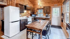 A wooden cabin kitchen with a refrigerator, stove, microwave, and wooden dining table. - Fantastic Lakefront Cabin W/ Free WiFi, Three Kayaks, Private Dock, & Firepit (Winthrop)