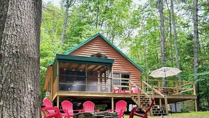 A cabin with a porch, red chairs, and a stone fireplace. - Fantastic Lakefront Cabin W/ Free WiFi, Three Kayaks, Private Dock, & Firepit (Winthrop)