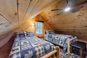 Eine Hütte mit zwei Betten, einem Deckenventilator und einem Fenster.