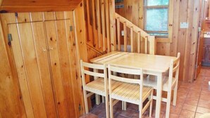 A wooden interior with a dining table and chairs, a staircase, and a window. - Dog-Friendly Lakefront Cottage w/Lake Access, Deck, Gas Grill, A/C (Standish)
