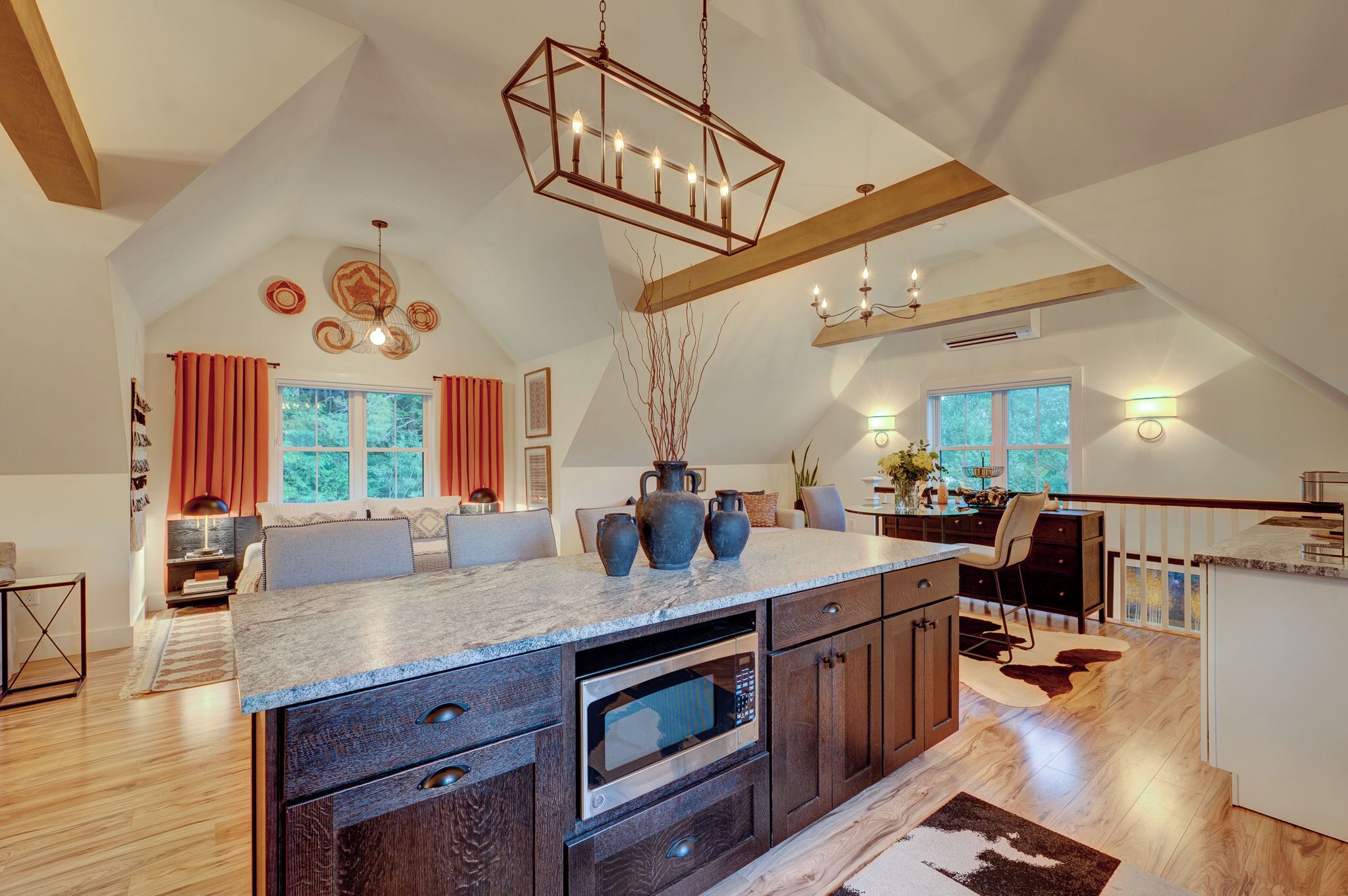 A spacious kitchen with a large island, built-in oven, and pendant lighting.