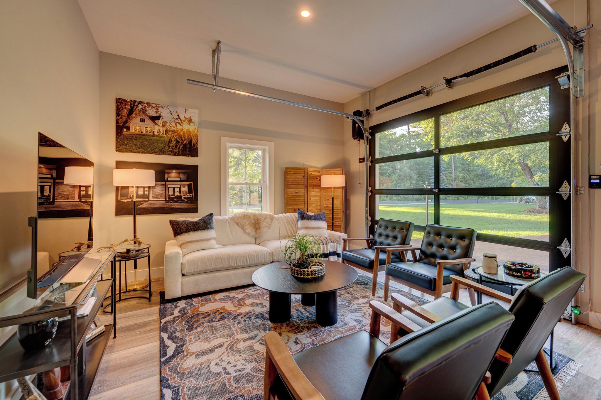 A spacious living room with a large window, a sofa, a coffee table, and a fireplace.