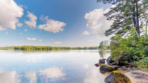 Un lago tranquilo con aguas cristalinas, rodeado de árboles y rocas.