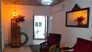 A cozy living room with a wooden ceiling, a red sofa, a wooden coffee table, and a mirror reflecting the room. - Renovated historic house in the center of Vva.de los Infantes. Groups and couples. (Villanueva de los Infantes)