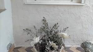A corner with a white-framed window, a wicker basket with plants, and patterned floor tiles. - Renovated historic house in the center of Vva.de los Infantes. Groups and couples. (Villanueva de los Infantes)
