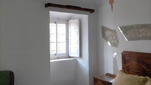 A bedroom with a bed, a window, a chair, and a tree mural on the ceiling. - Renovated historic house in the center of Vva.de los Infantes. Groups and couples. (Villanueva de los Infantes)