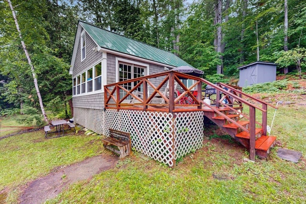 Eine Holzhütte mit einer Holzterrasse und einer Treppe, die zu einer Veranda führt.