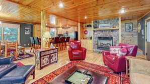 A cozy interior with wooden ceilings, a fireplace, and leather furniture. - Log cabin 1 mile from Sunday River with hot tub, fireplace & Ping-Pong (Newry)