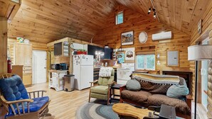 A cabin interior with a kitchen, dining area, and living room. - Charming Lakeview House with Deck, Cozy Fireplace and firepit (Rome)